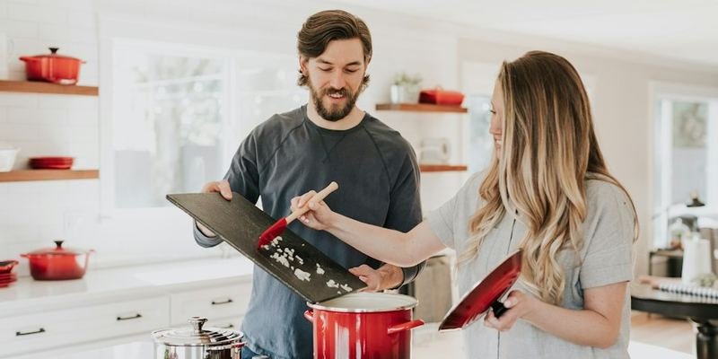 Couple cooking on a range in a bright kitchen